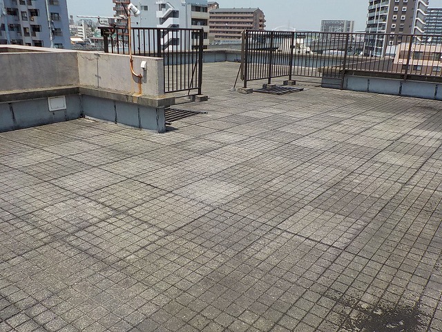 ブロックが敷かれた陸屋根の<br>防水事例（シート防水）